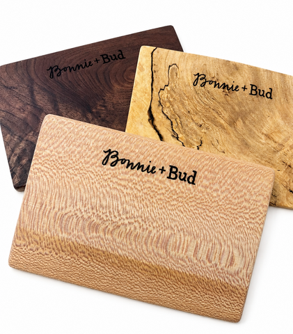 Three personalized wooden cutting boards with the names 'Bonnie + Bud' engraved on them, displayed on a clean white background.
