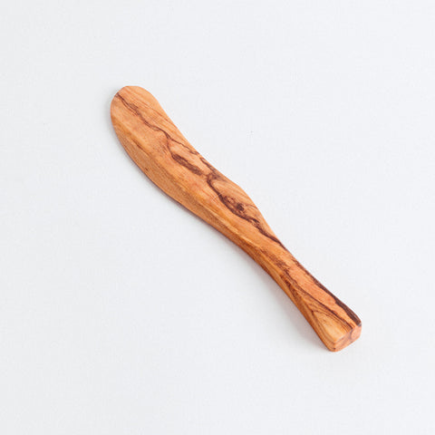 A wooden knife with a smooth, dark finish on a light background.