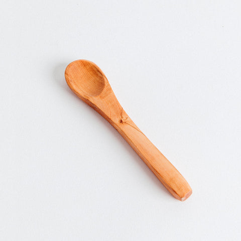 A smooth, olivewood appetizer spoon with a slotted bowl and a solid handle, placed on a white background.
