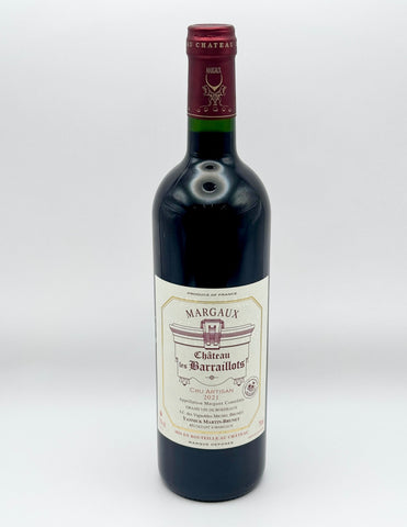 A bottle of Margaux Château les Barraillots red wine, featuring a dark glass bottle with a cream-colored label and a dark red foil capsule at the neck, set against a plain light gray background.