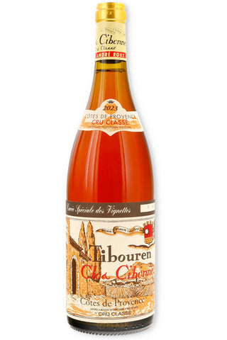 A bottle of Tibouren Chârogne Côtes de Provence Cru Classique red wine, featuring a large cream-colored label with illustrations of a church and a red sun emblem, on a white background.