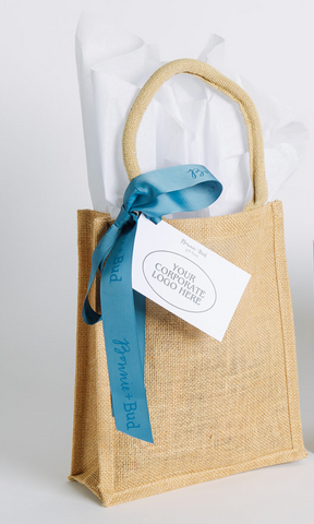 Jute bag with a blue ribbon and a tag on a white background