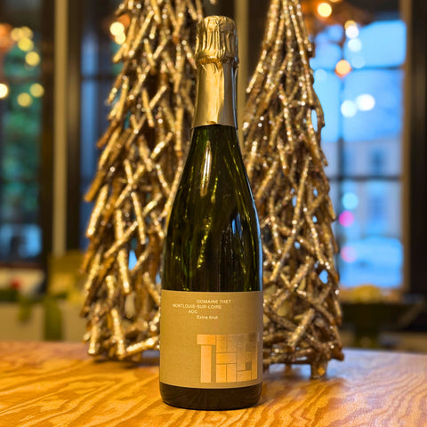 Wine bottle on a wooden table with decorative trees in the background
