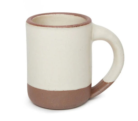 A ceramic mug with a matte off-white body, a brown base, and a brown rim, shown on a plain white background.