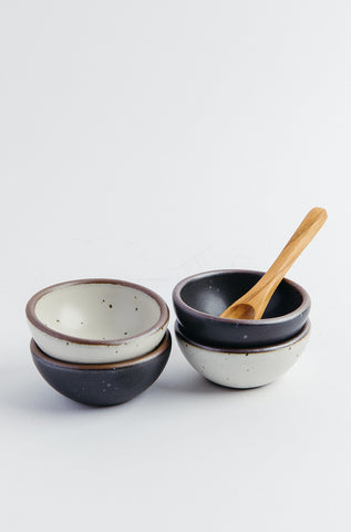 Set of ceramic bowls with a wooden spoon on a white background