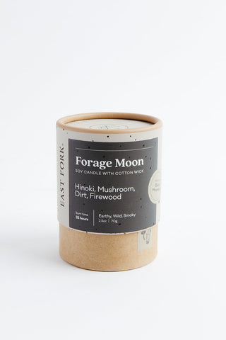 Candle in a cardboard tube with 'Forage Moon' label on a white background