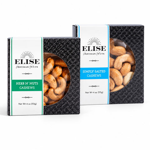 Two boxes of Elise Artisan Nuts cashews on a white background. The smaller box on the left is Herb N' Nuts Cashews with a green label, and the larger box on the right is Simply Salted Cashews with a blue label.
