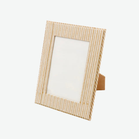 A rectangular picture frame with a textured vertical striped pattern in light beige and cream, featuring a small brown wooden easel stand visible on the right side, set against a plain light gray background.