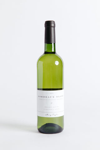 A bottle of Mary Taylor Bordeaux Blanc wine with a white label on a clear background.