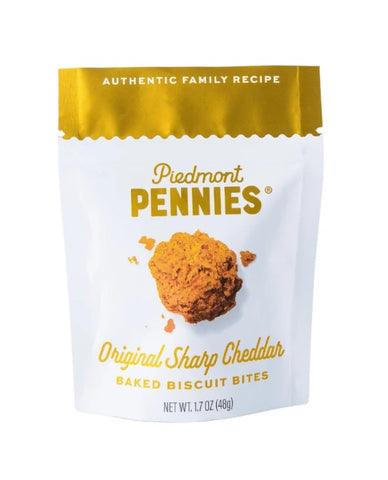 A stand-up pouch of Piedmont Pennies Original Sharp Cheddar Baked Biscuit Bites on a plain white background. The packaging features a white body with a metallic gold top seal and gold text, with a photo of a baked biscuit bite in the center.