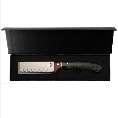 A kitchen knife with a dark textured handle and a silver blade featuring a serrated edge, presented inside an open black gift box on a white background.