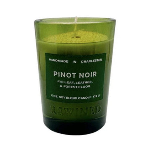 A 6 oz soy candle in a translucent olive green glass jar with a dark green label reading 'PINOT NOIR' and 'HANDMADE IN CHARLESTON'.