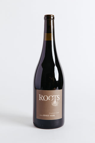 A bottle of Roots Crosshairs Cuvee Pinot Noir wine with a white label on a clear background.