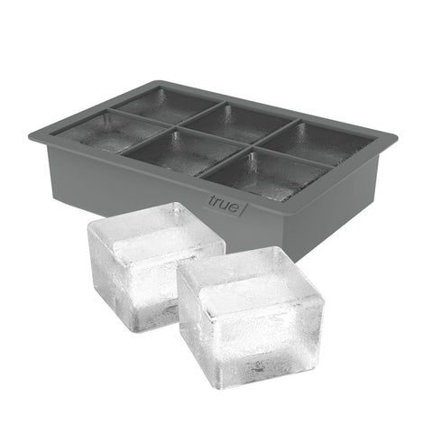 Gray ice cube tray with two made ice cubes on a white background
