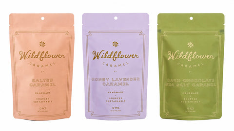 Three stand-up pouches of Wildflower Caramel chocolates in peach, lavender, and olive green, shown side by side on a white background.