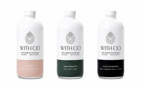 Three white bottles of WITH CO. Cocktail mixers on a white background, showing different flavor