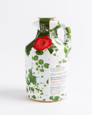 A ceramic jar of Frantoio Galantino extra virgin olive oil with a hand-painted design in green and gold colors, featuring a red label on the neck.