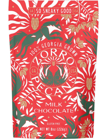 A stand-up pouch of Zorro Pecans Milk Chocolate with a festive red, green, and white patterned design featuring pecan trees and a central Zorro logo.