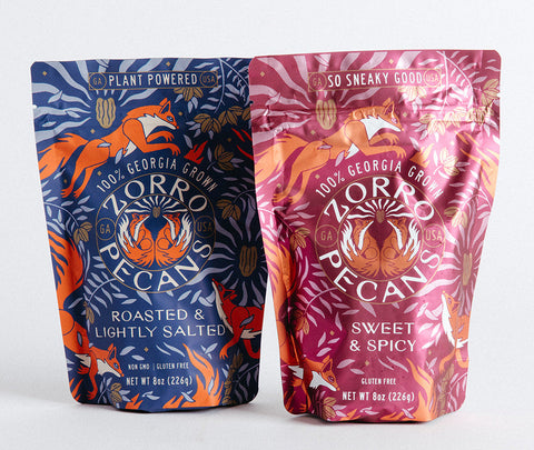 Two packages of Zorro pecans, one labeled lightly salted and the other sweet & spicy, against a white background.