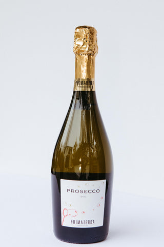 A bottle of Primaterra Prosecco sparkling wine with a pale gold label, creamy texture, and visible carbonation.